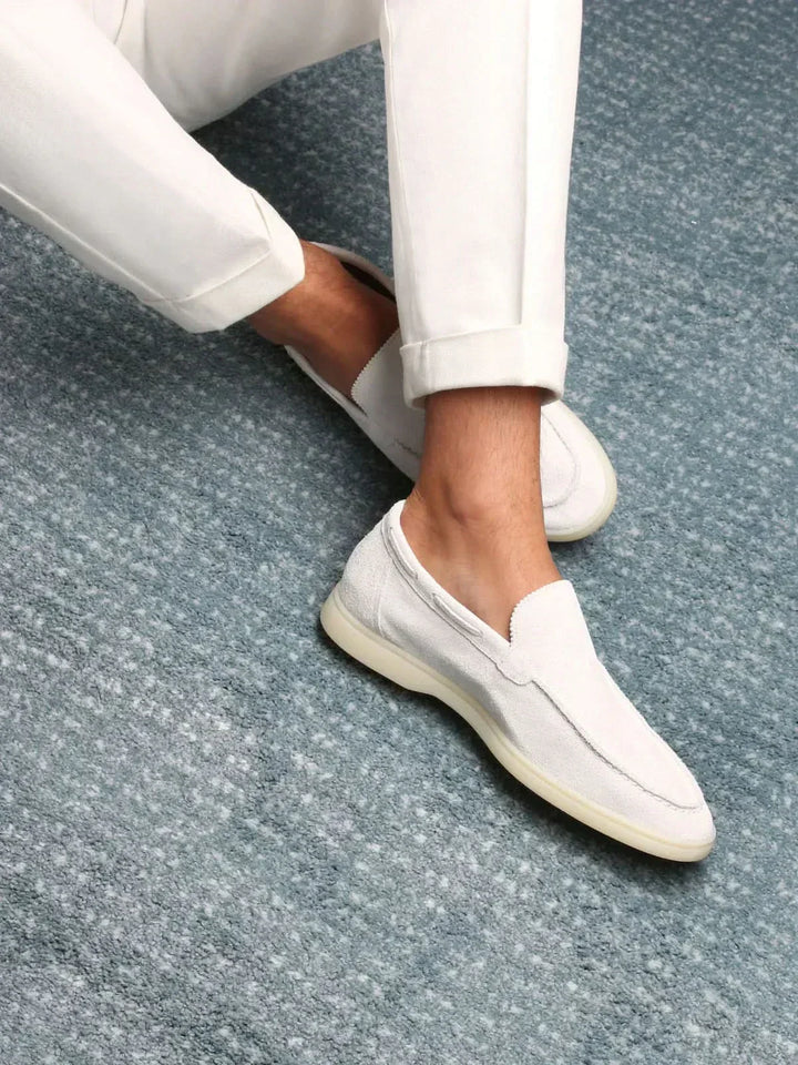 Men's white moc toe slip-on loafers with stitched detailing and flat soles