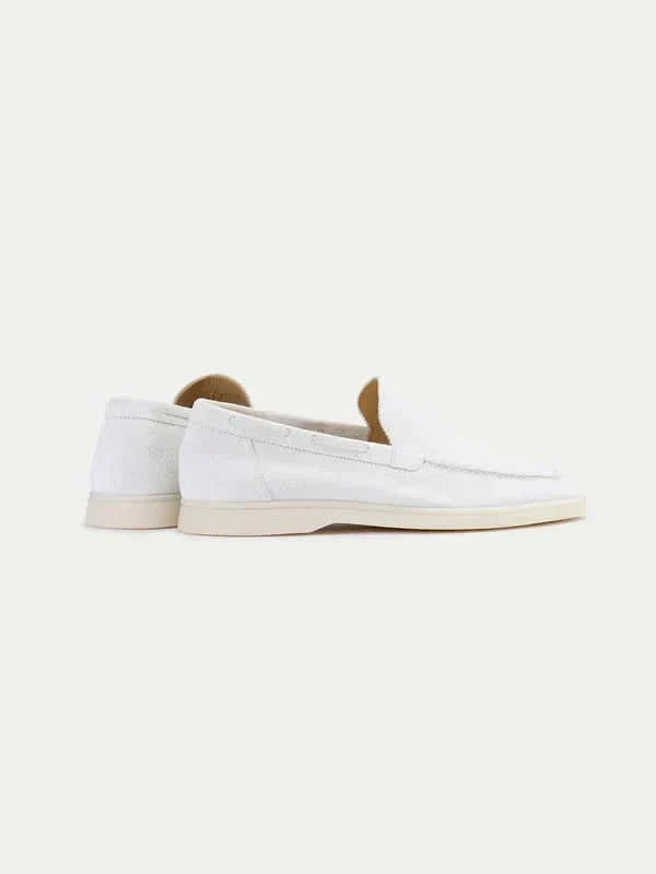 Men's white moc toe slip-on loafers with stitched detailing and flat soles