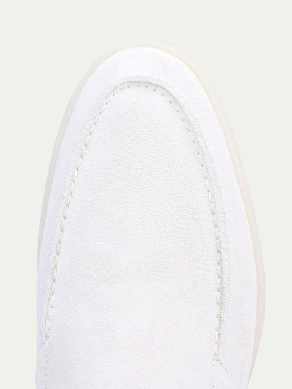 Men's white moc toe slip-on loafers with stitched detailing and flat soles