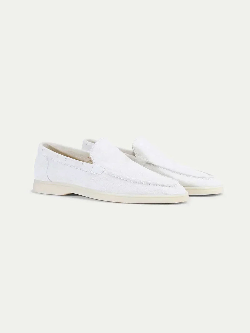 Men's white moc toe slip-on loafers with stitched detailing and flat soles