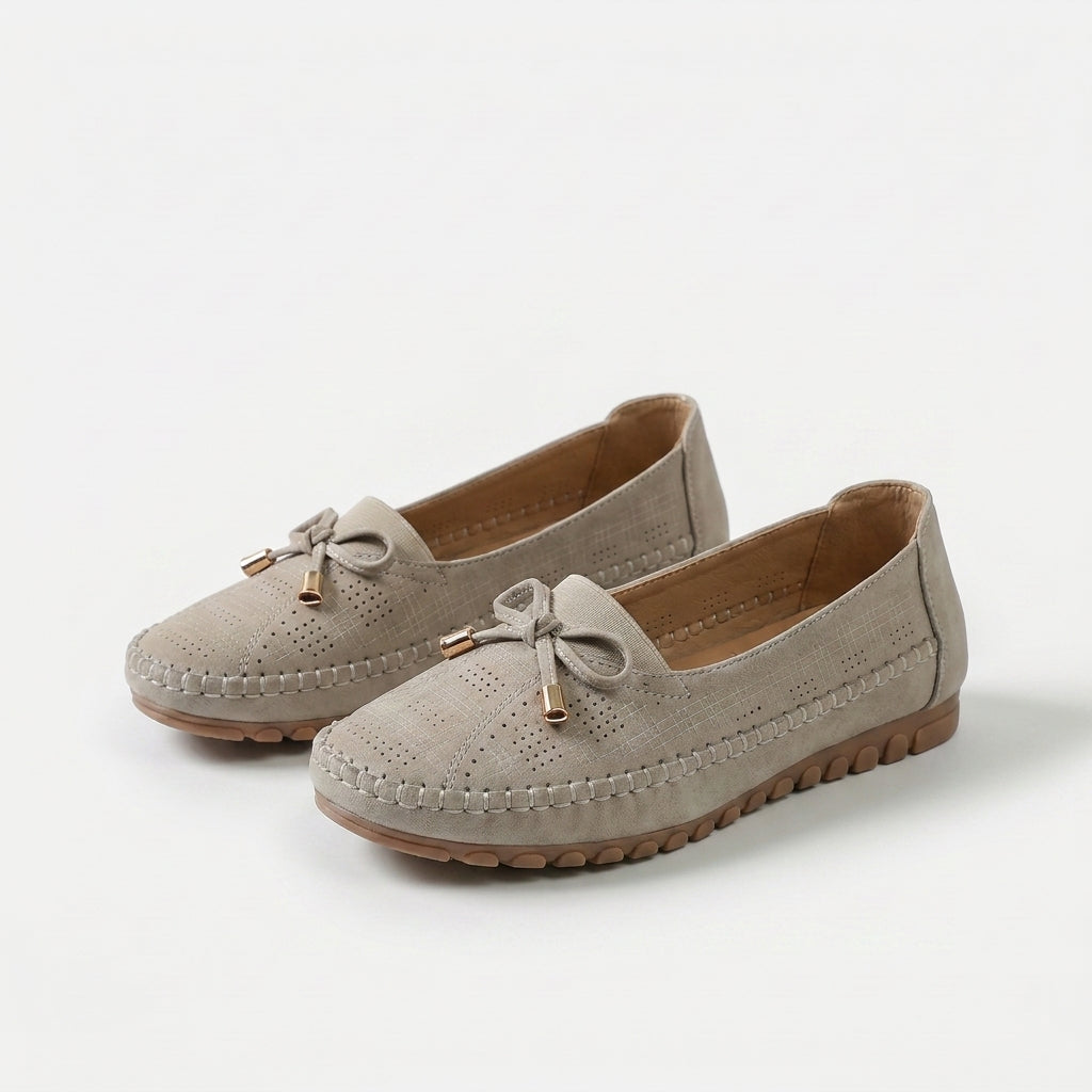 Women's perforated loafers with decorative bows and flat segmented soles