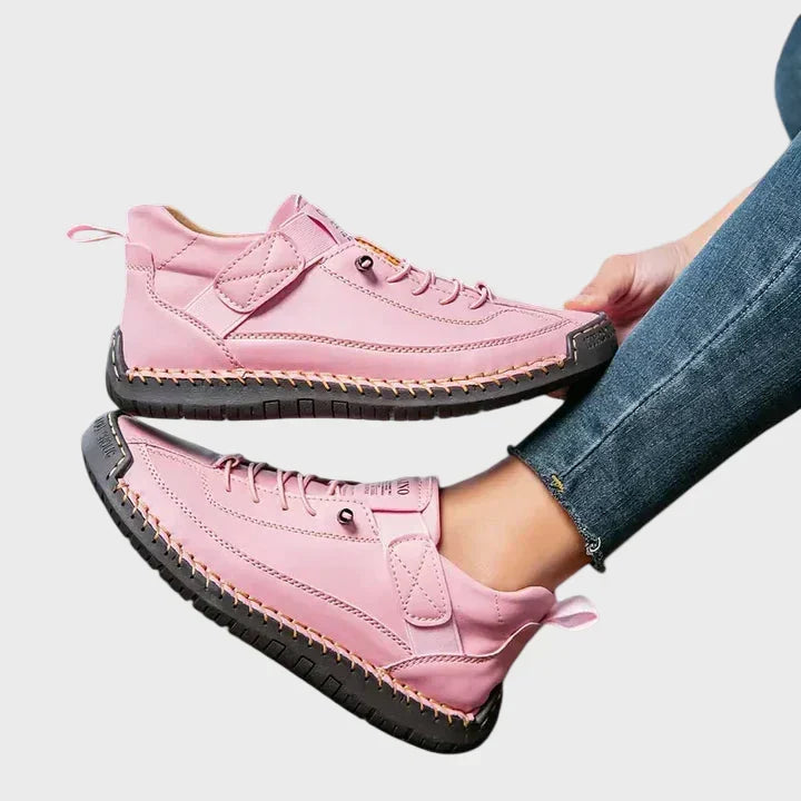 Orthopedic sneakers with white upper and beige sole, worn with jeans