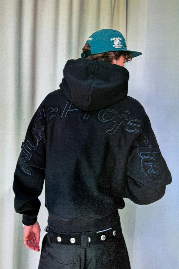 Black hooded sweatshirt with raised lettering on the back and sleeves