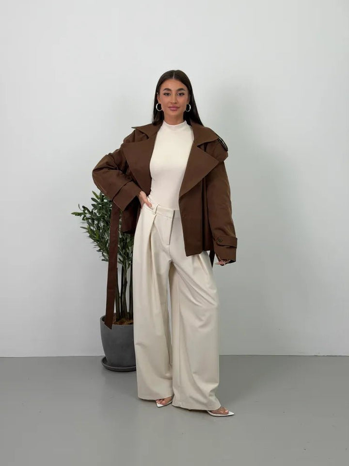 Women's brown cropped trench coat with wide lapels and belt
