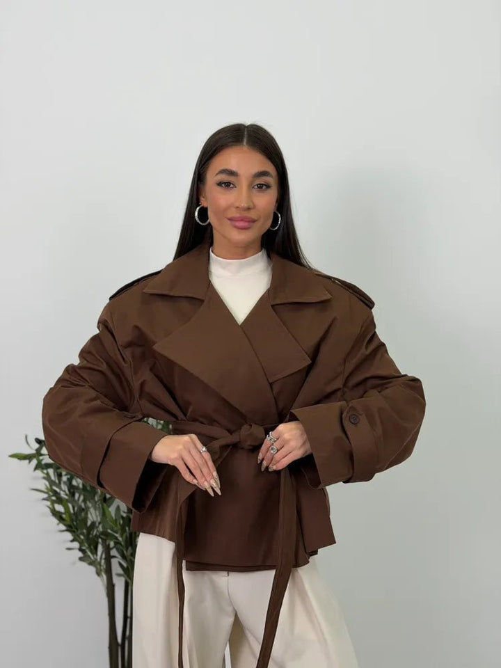 Women's brown cropped trench coat with wide lapels and belt