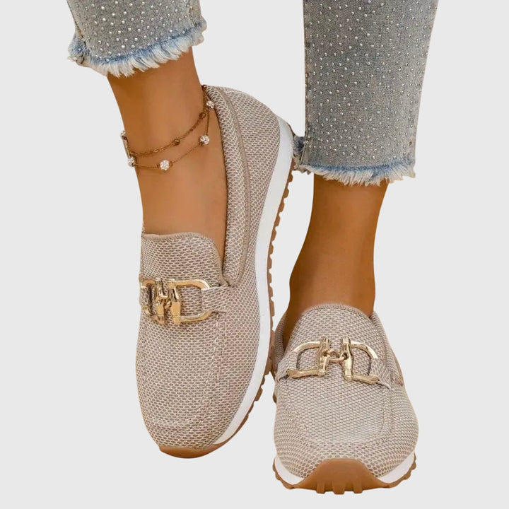 Women's textured knit loafers with gold buckle detail and cushioned sole, shown in blue and beige.